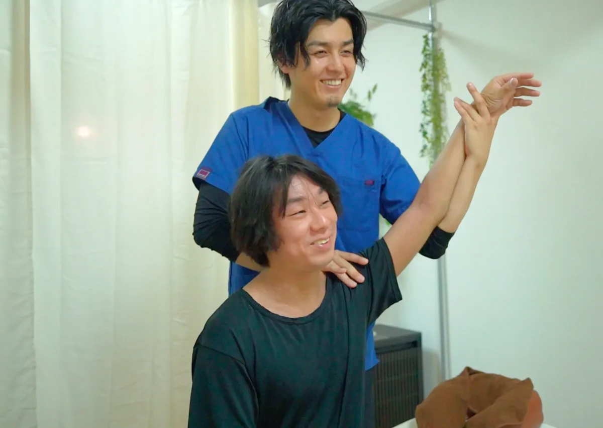 六本木の整体サロン「モビリティ整体ソシオ」で、施術後に肩や腕の可動域を再チェックしている様子。整体師がお客様と一緒に動きやすさの変化を確認しているシーン。