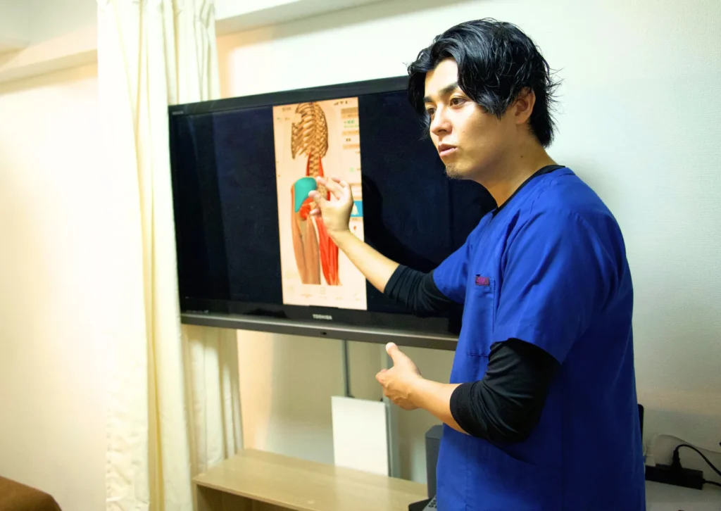 六本木の整体モビリティ整体ソシオで行う重心・バランス検査|検査結果を専門用語を使わず画面を見ながら分かりやすく説明している様子