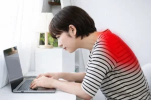 六本木の整体モビリティ整体ソシオ｜デスクワーク中に背中が丸くなっている猫背の姿勢のイメージ