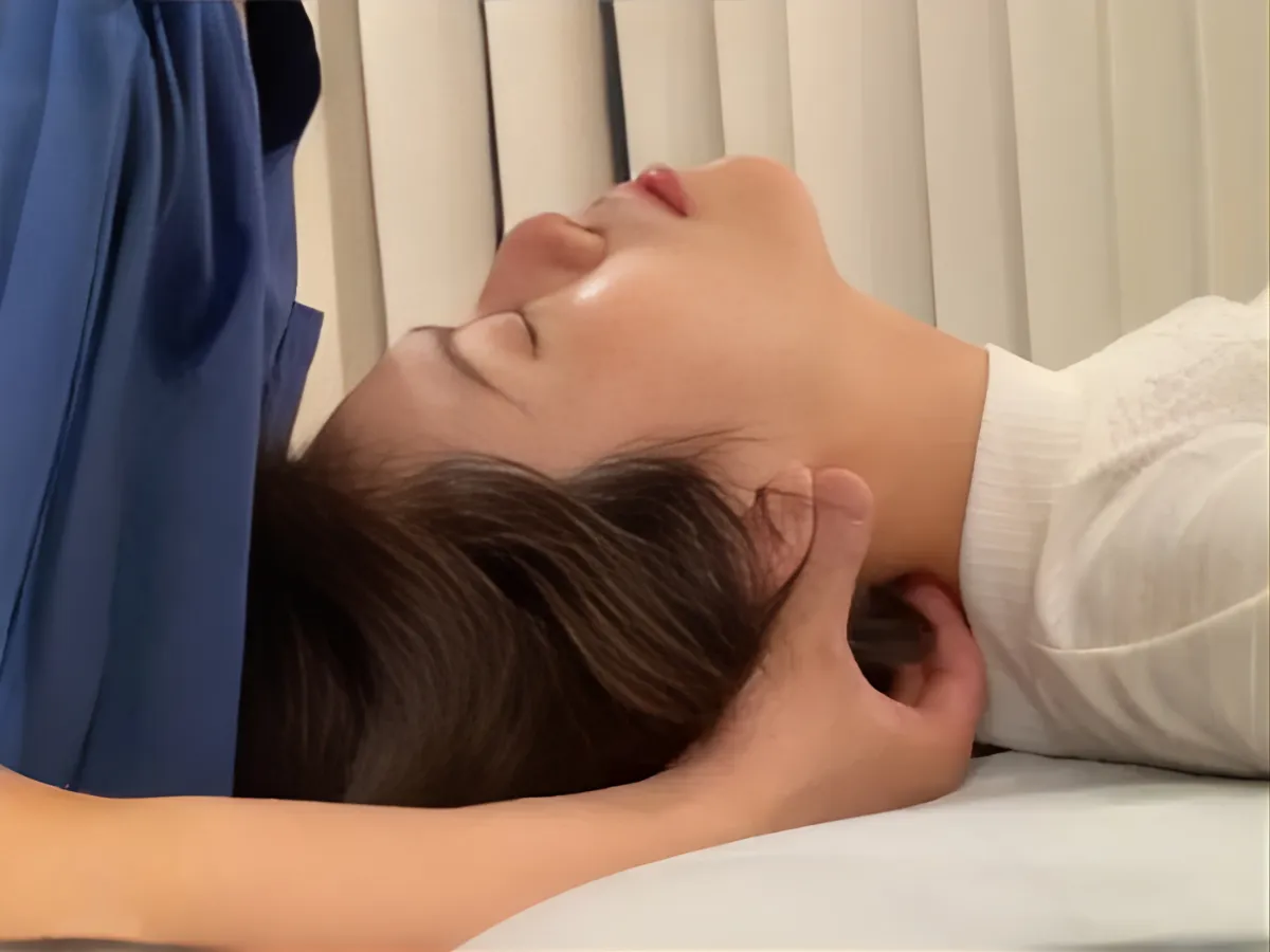 六本木の整体で患者様の首まわりと頭部をケアする柔道整復師