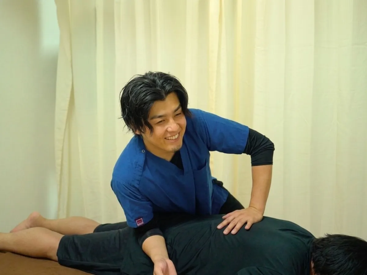 六本木の整体でうつ伏せの患者様の腰から骨盤まわりを施術する柔道整復師